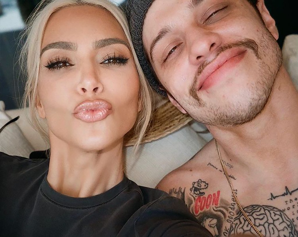 Pete Davidson and Kim Kardashian taking a selfie, displaying Davidson's tattoos referencing their relationship and Kardashian's children