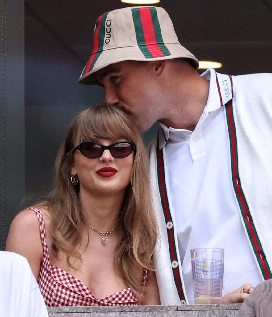 Travis Kelce kisses Taylor Swift on the head.