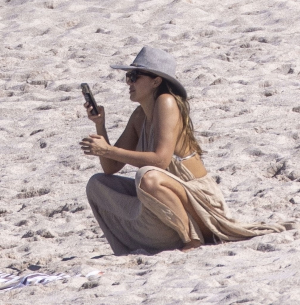 Jessica Alba on her phone at the beach in Mexico.