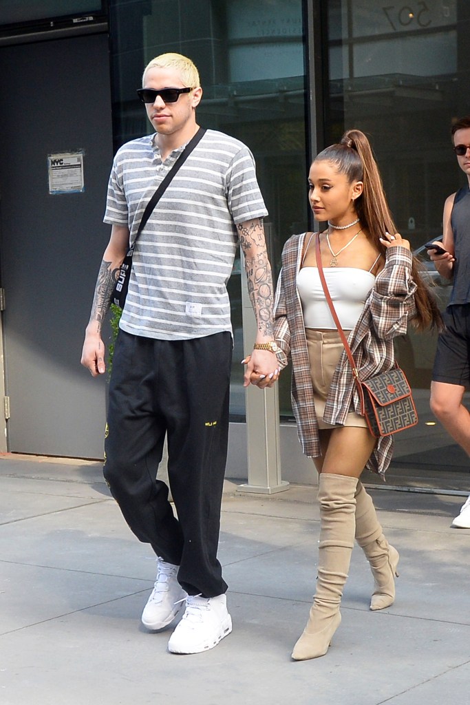 Ariana Grande and Pete Davidson holding hands while exiting their apartment in New York City