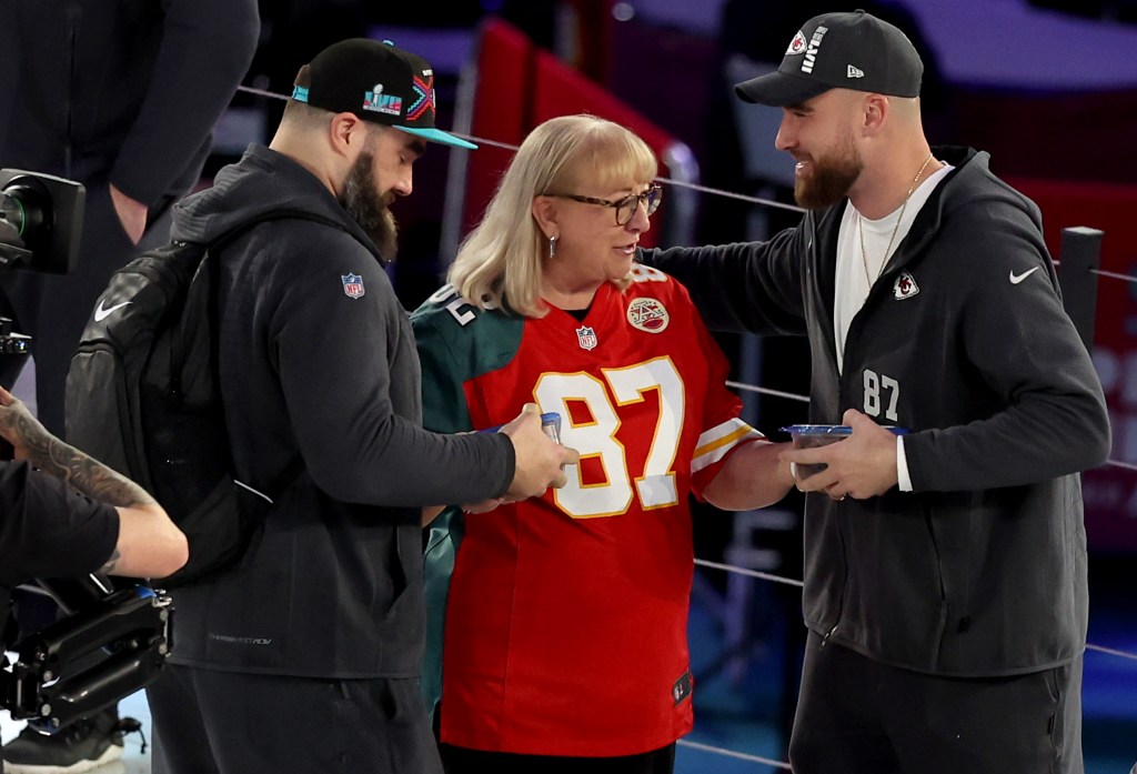 Mother Donna Kelce (C) gives cookies to her son's Jason Kelce (L) #62 of the Philadelphia Eagles and Travis Kelce (R) #87 of the Kansas City Chiefs during Super Bowl LVII Opening Night presented by Fast Twitch at Footprint Center on February 06, 2023 in Phoenix, Arizona.