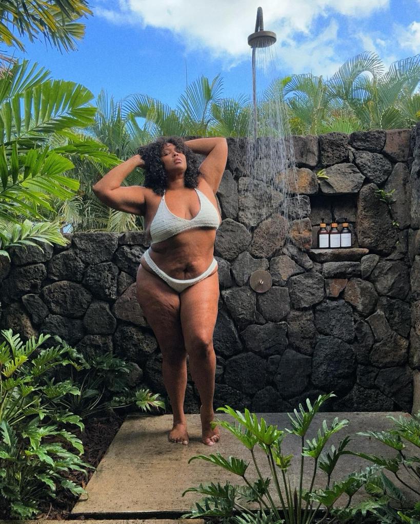 Lizzo wearing a bikini and taking an outdoor shower.