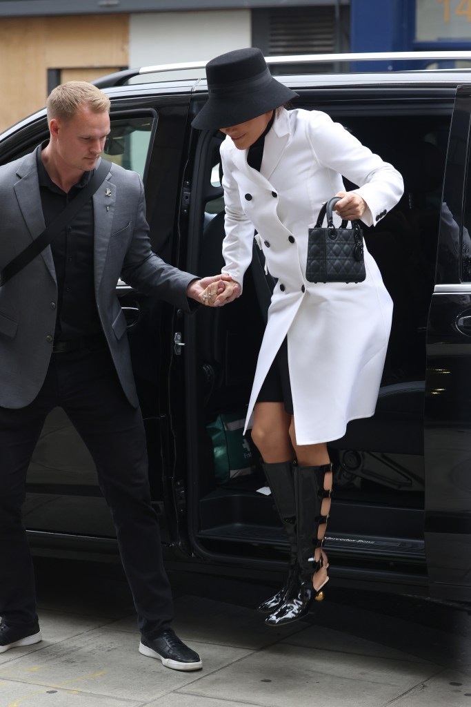 Jennifer Lopez being helped out of a car by her bodyguard in London