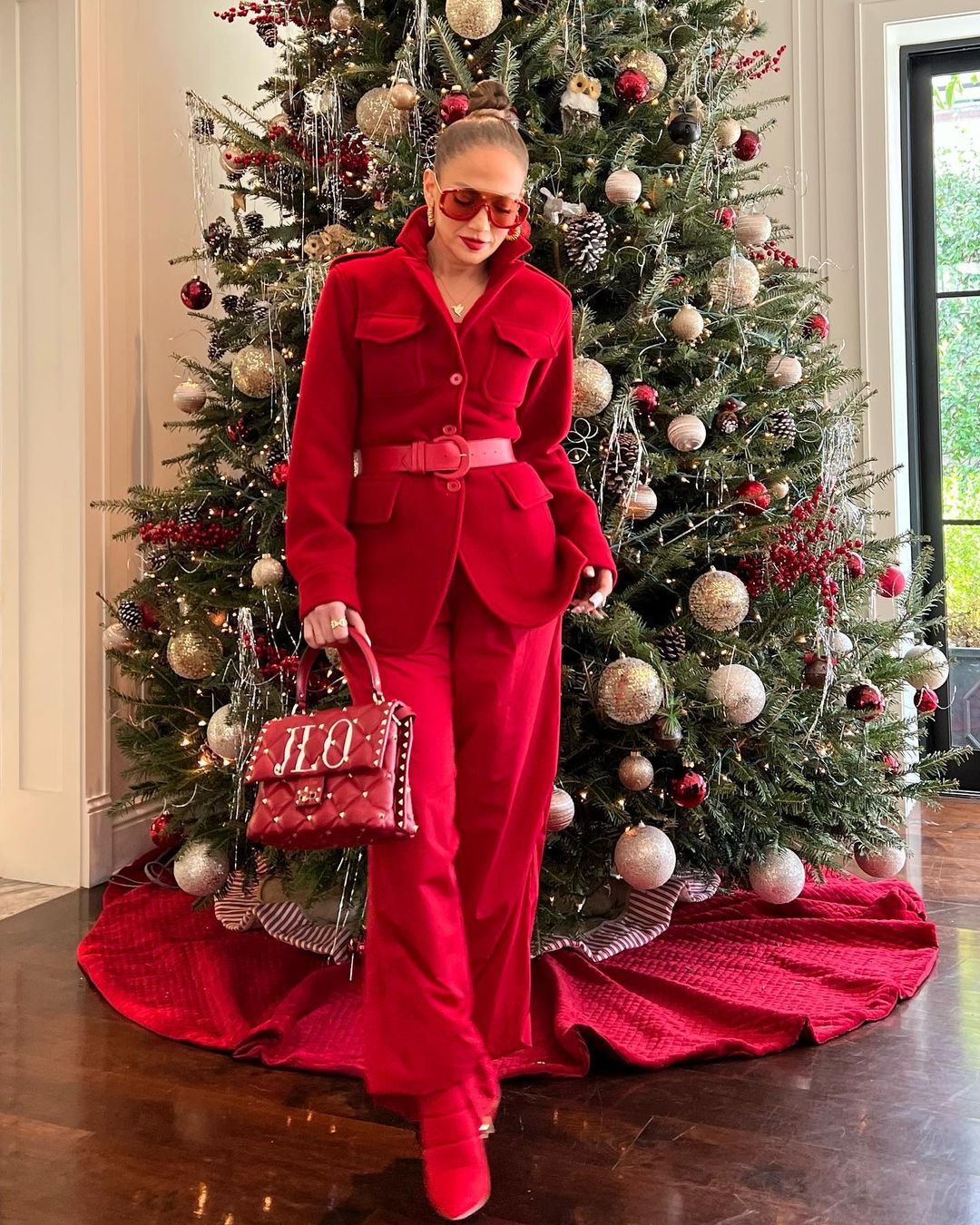 Jenifer Lopez posing in front of a Christmas tree