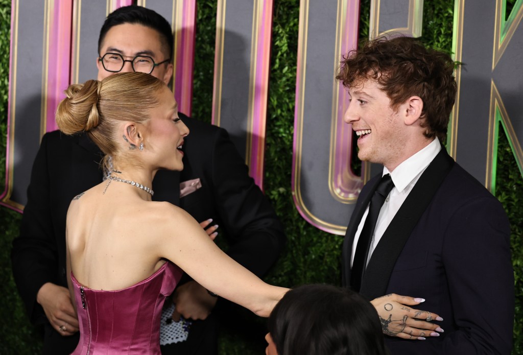 Ariana Grande touches Ethan Slater's suit on the Red Carpet.