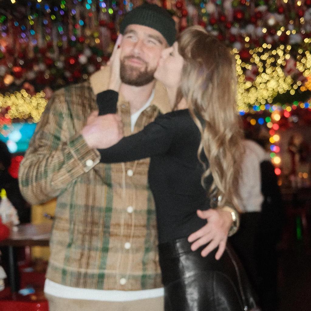 Taylor Swift kissing Travis Kelce on the cheek.