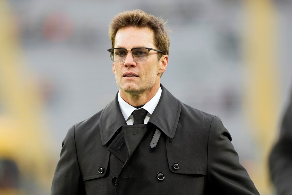 Tom Brady in a coat and glasses.