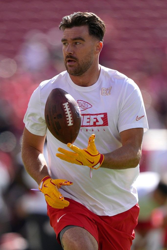 Travis Kelce running with a football during football practice