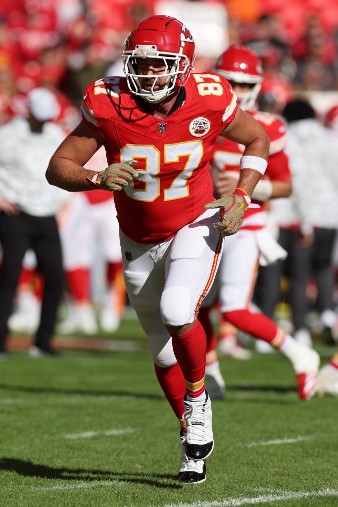 Travis Kelce running on the field in his football uniform.