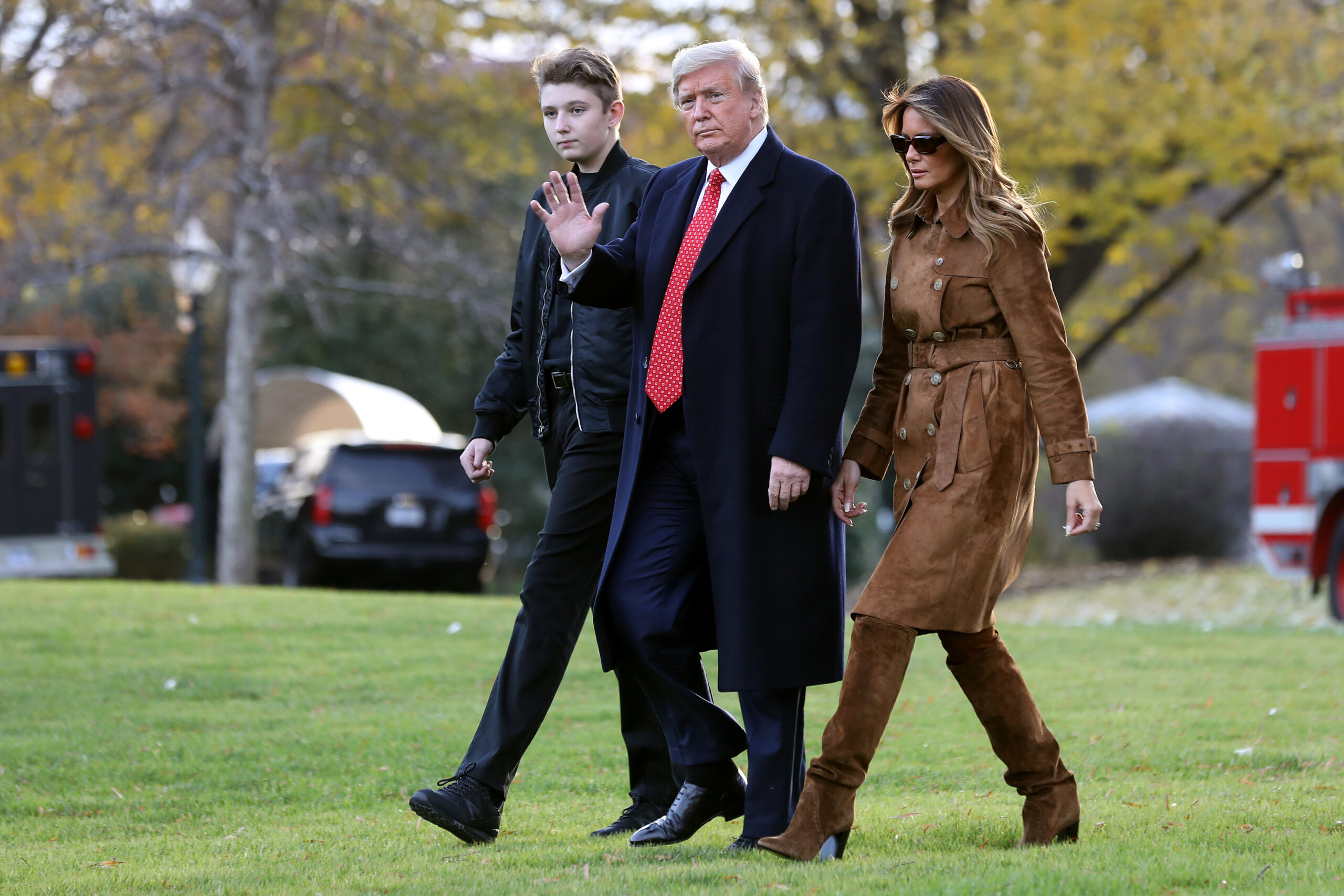 Donald Trump, Melania Trump and Barron Trump walking across the lawn in 2019.