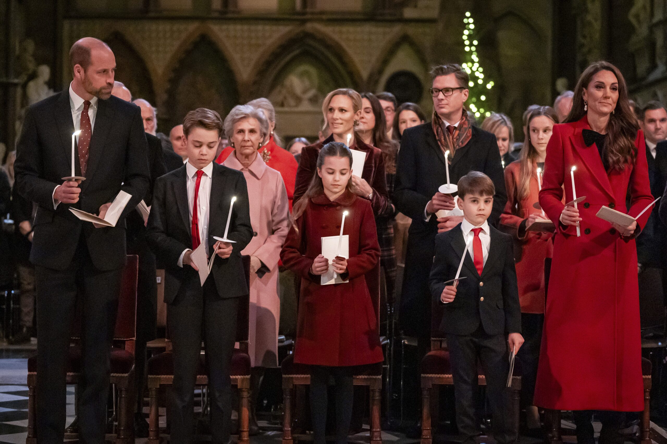 Prince William, Prince George, Princess Charlotte, Prince Louis and Kate Middleton hold candles at a carol service.