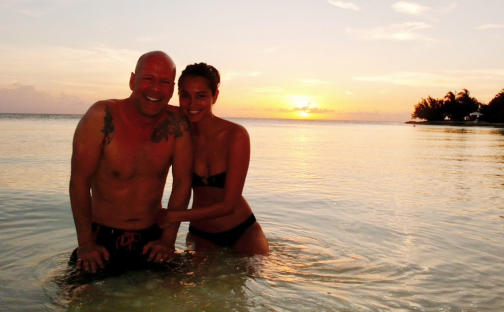 Bruce Willis and his wife, Emma Heming, posing in the ocean.