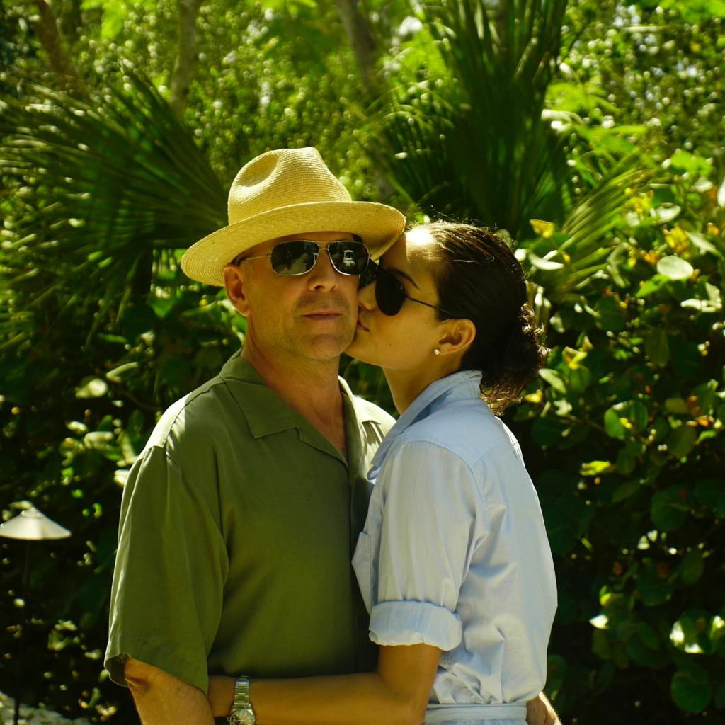 Bruce Willis and Emma Heming kissing.