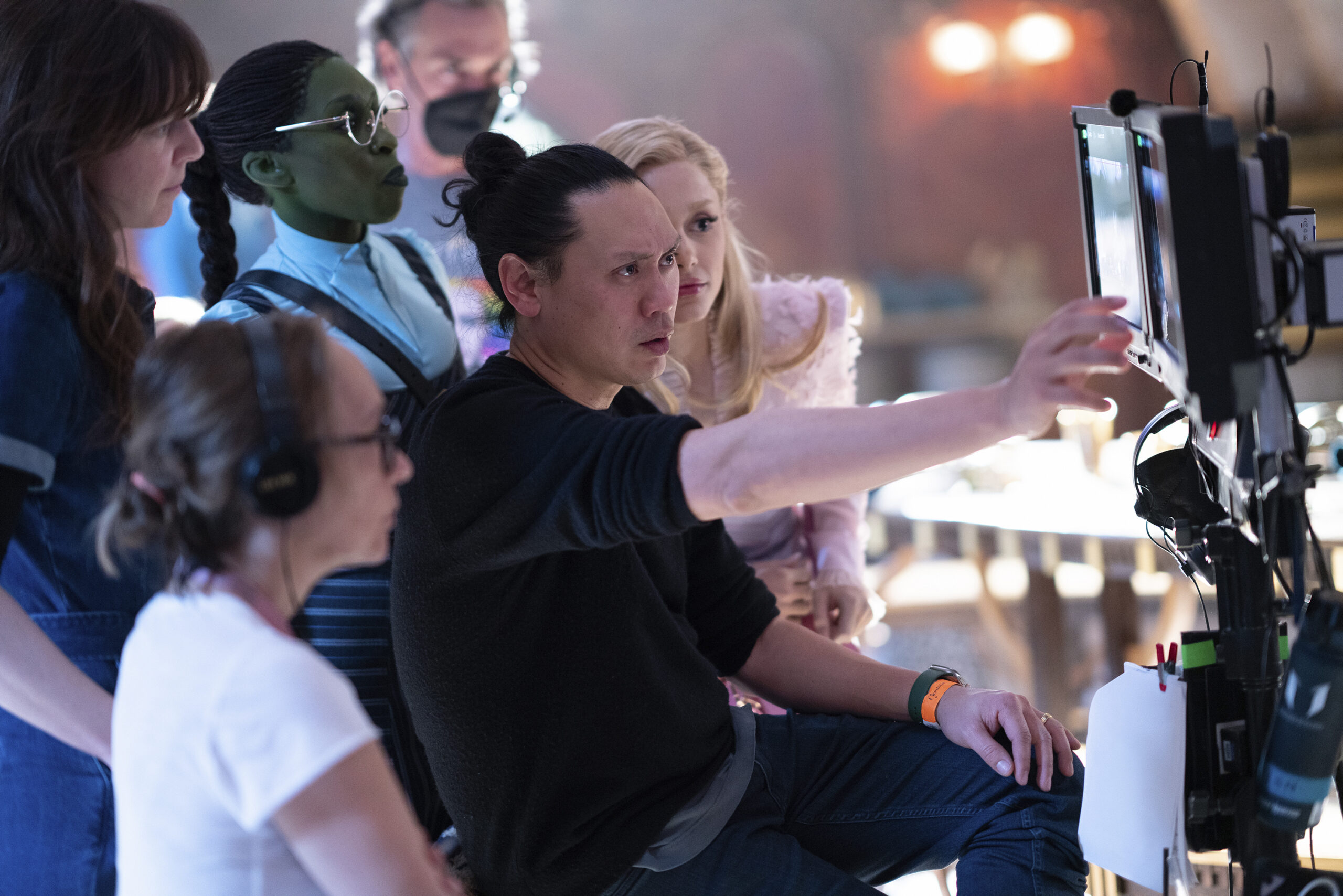 Jon M. Chu, center, with cast and crew on the set of the film "Wicked"