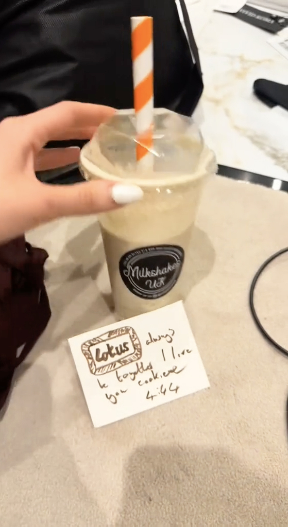 Kate Cassidy holding a milkshake and a note from Liam Payne