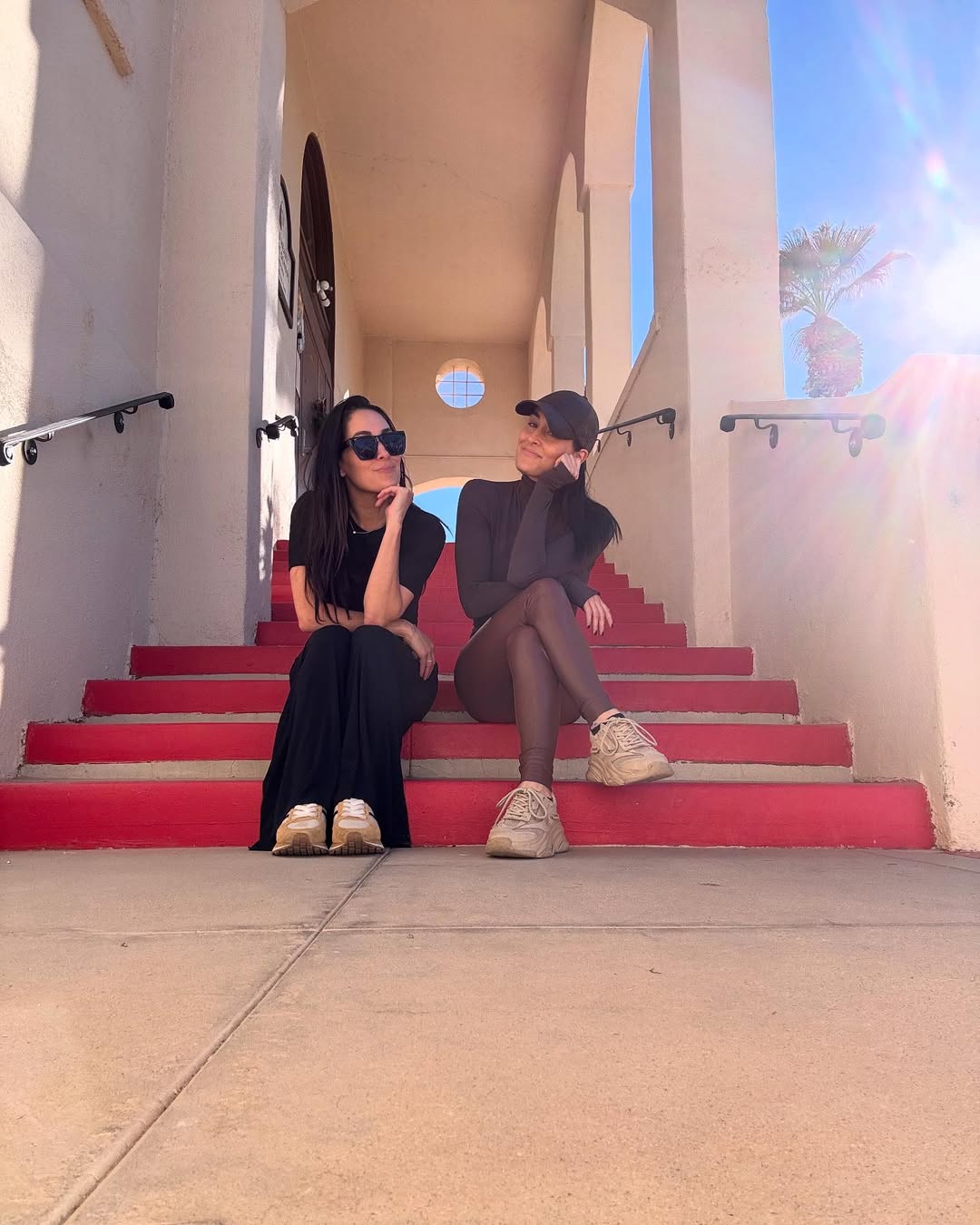 Nikki Garcia and sister Brie Garcia sitting on the steps.