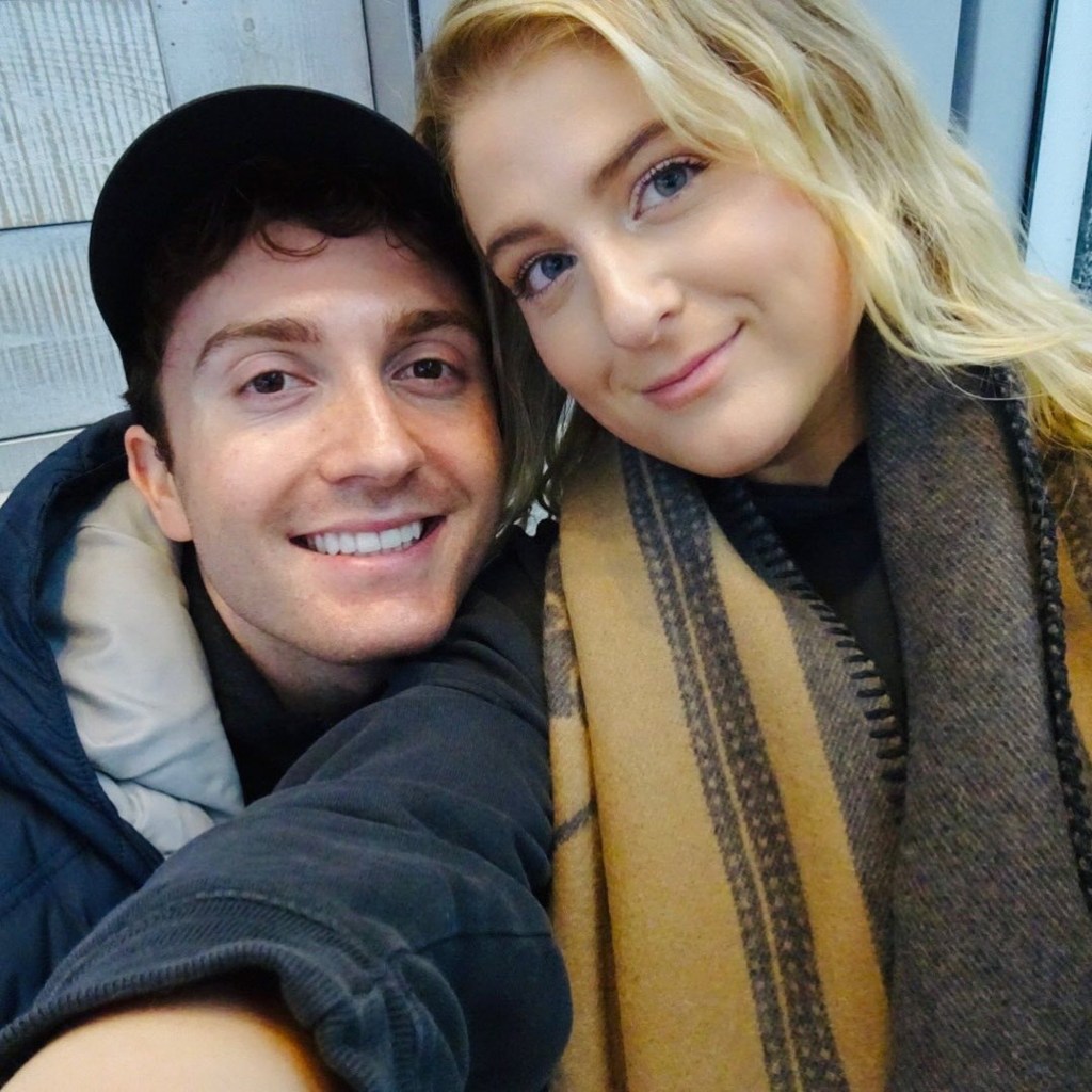 Meghan Trainor posing with her husband.