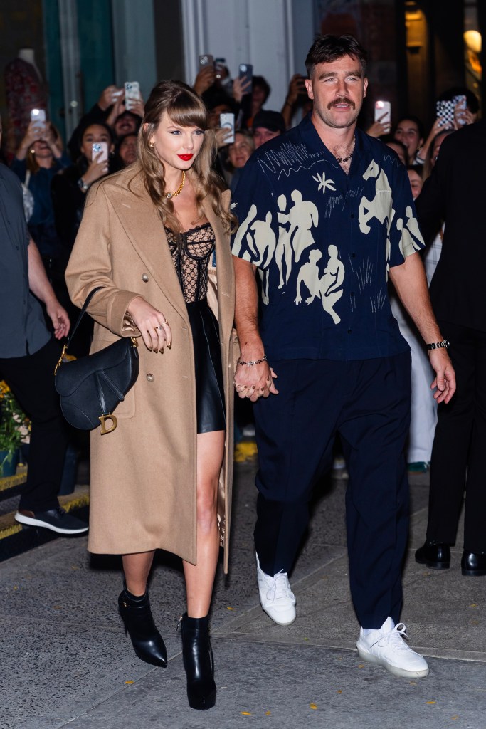 Taylor Swift and Travis Kelce holding hands.