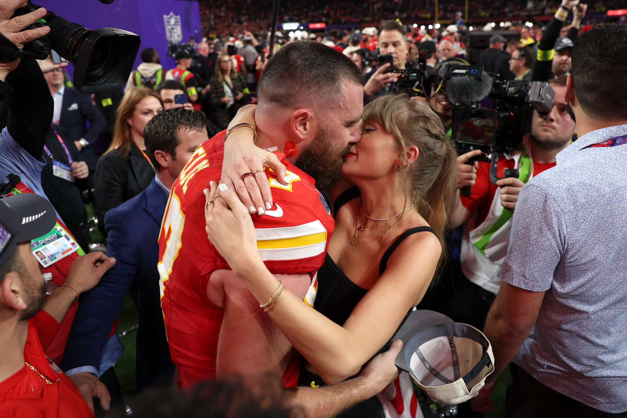 Taylor Swift and Travis Kelce kissing.