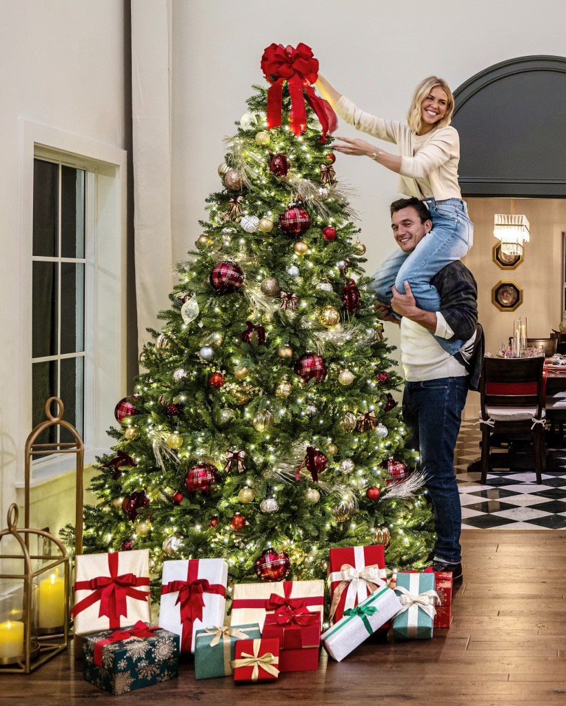 Tyler Cameron and Tate Madden next to a Christmas tree.