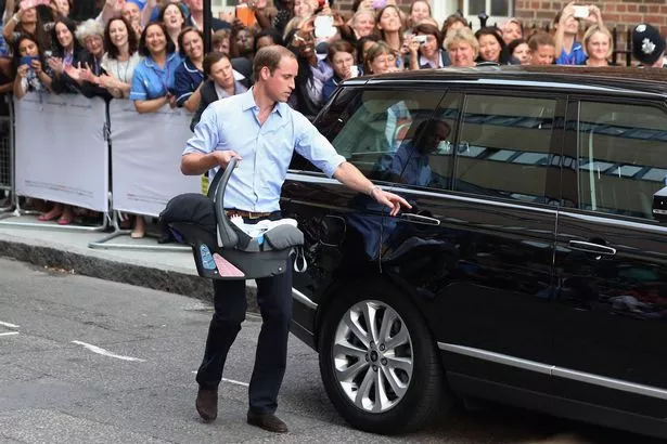 Prince William approaching a car carrying a baby