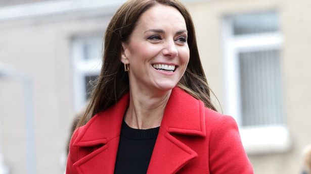 Kate Middleton wearing a red coat, smiling