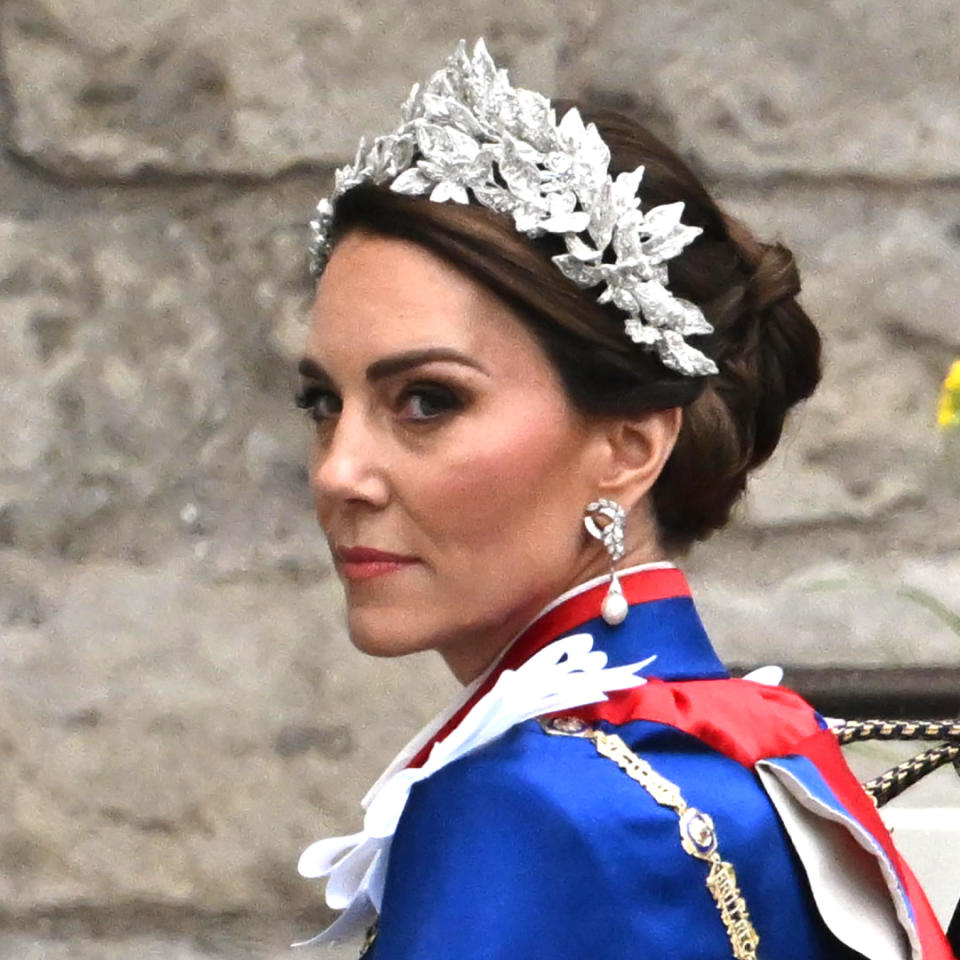  Kate Middleton wears a royal blue and red cloak and a glittering crown of leaves. 