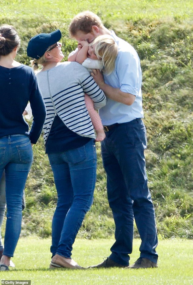 Prince Harry playfully hugging the toddler at a polo match in 2016