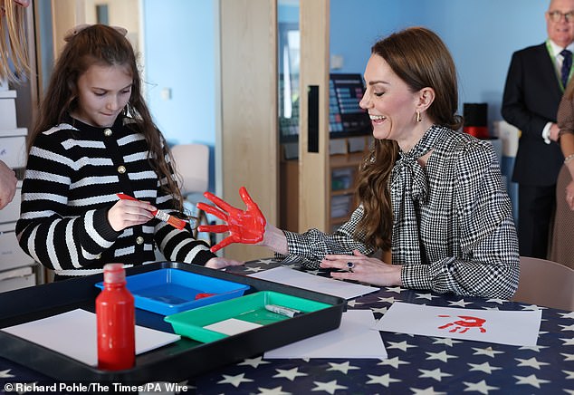 Kate gets crafty! The Princess made art with her hands with the help of a young girl who painted her palm bright red