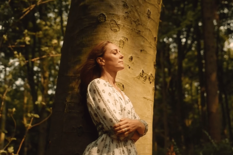 Kate Middleton stands with her eyes closed in front of a tree in a still from her video announcing she had finished chemotherapy.