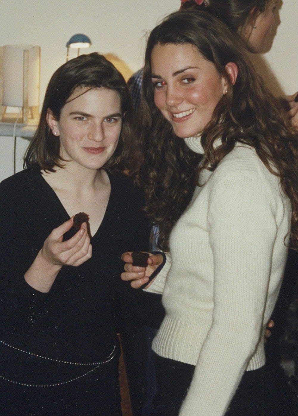 Laura Warshauer wearing a black long-sleeved sweater standing next to Kate Middleton wearing a white long-sleeved sweater