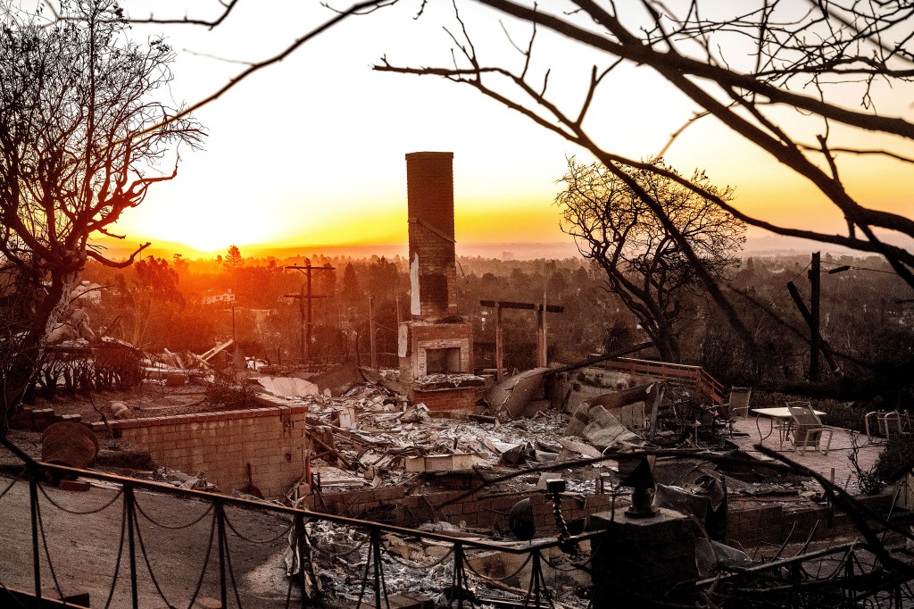 The sun rises behind a home destroyed by the Palisades Fire in the Pacific Palisades community of Los Angeles on Sunday.