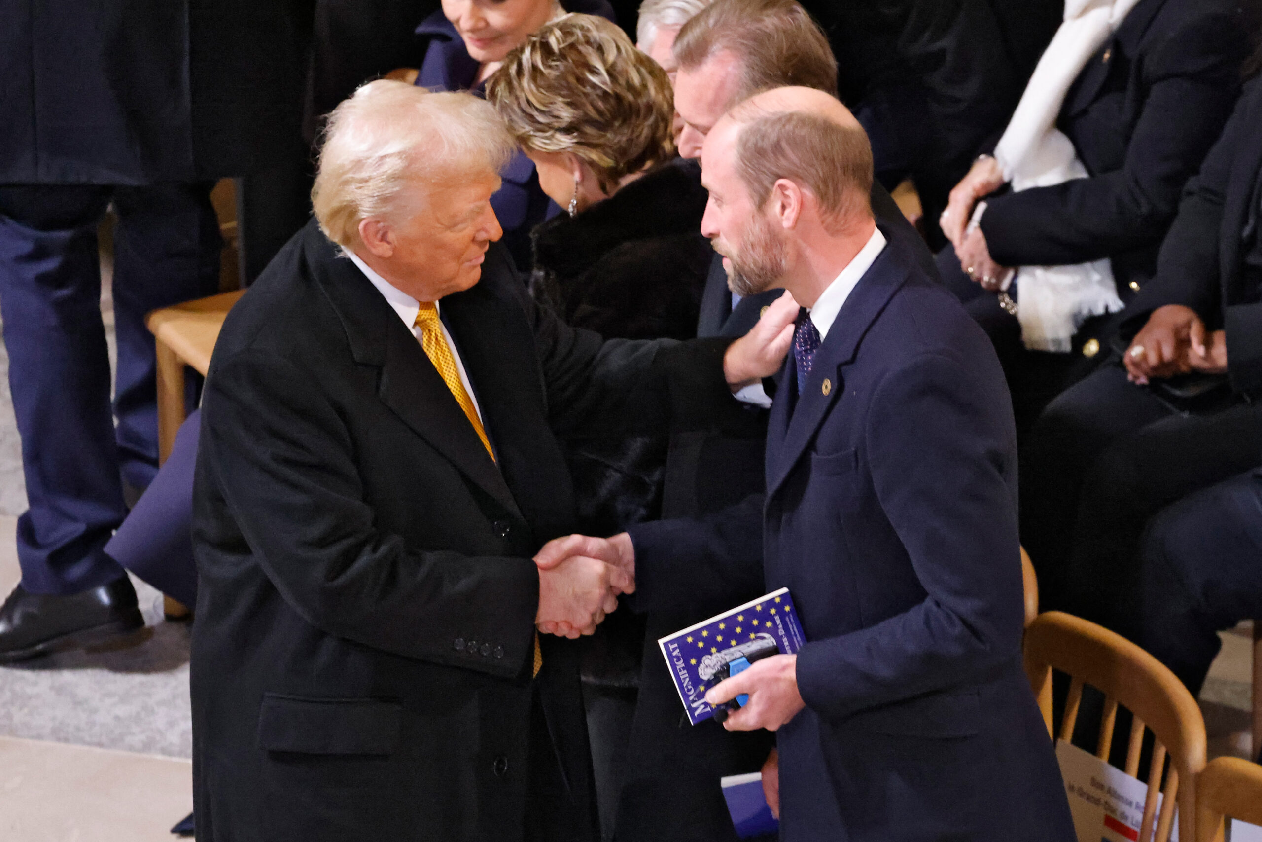 Donald Trump shaking hands with Prince William at Notre-Dame Cathedral.