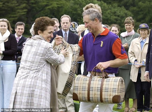 Prince Charles seen with Burberry Chief, Rose Maria Bravo in 2002. Burberry was awarded a Royal Warrant in 1955 by Queen Elizabeth II for waterproof trench coat