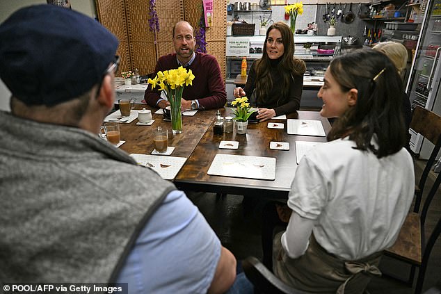 The couple pictured talking with people about the recent flooding in Wales - during a visit to Pontypridd Market