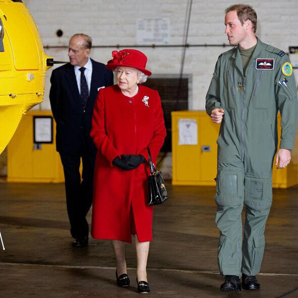 Prince William shows his grandmother Queen Elizabeth II around a helicopter