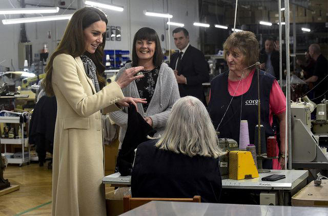 REBECCA NADEN/POOL/AFP via Getty Catherine, Princess of Wales (L) spends time with members of the production team on the factory floor during a visit to Corgi, a family run textiles manufacturer focused on the production of socks and knitwear on Jan. 30, 2025 in Ammanford, Wales