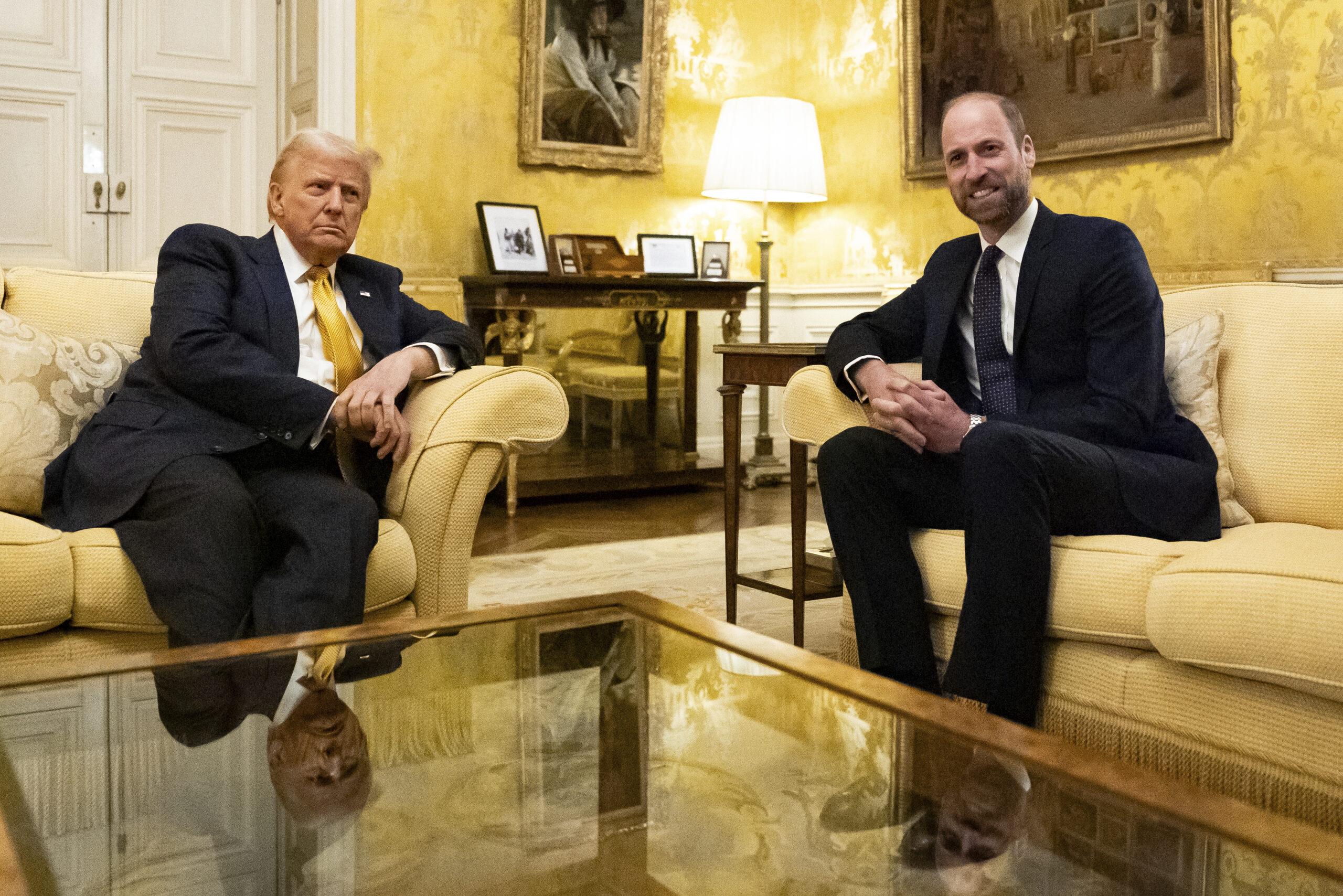 Prince William and Donald Trump seated on a sofa.