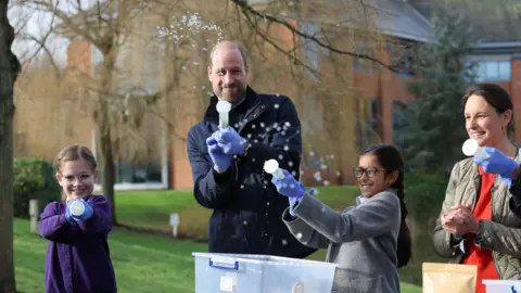 Richard Pohle/The Times/PA Wire The Prince of Wales with local schoolchildren as they filter DNA samples through a syringe after extracting water from a local pond in order to see which species live in it