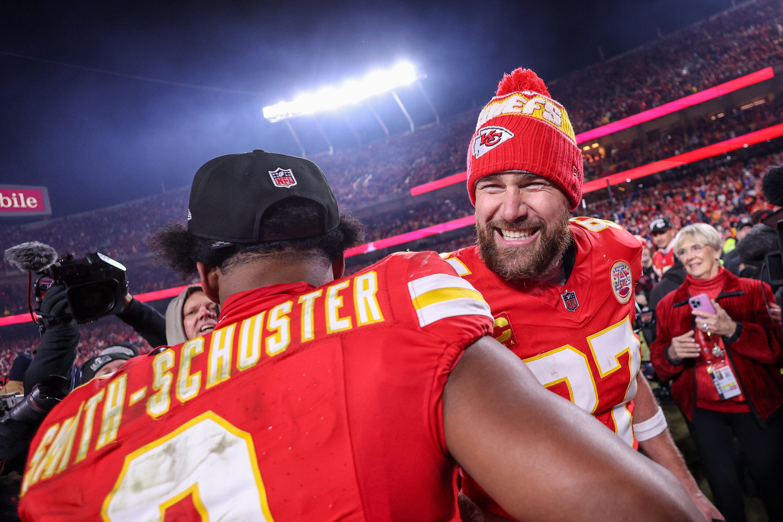 Travis Kelce smiling while with a teammate.