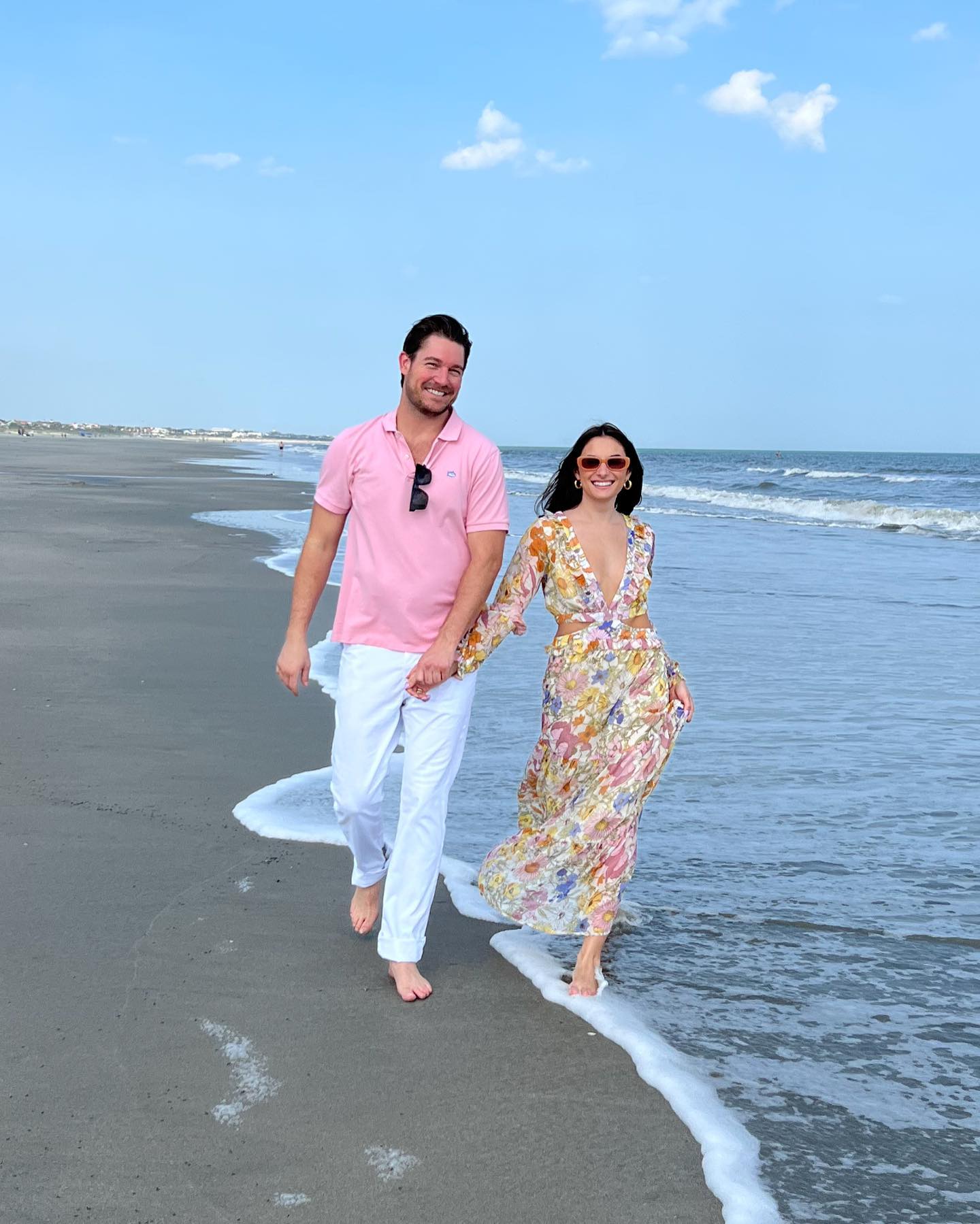 Paige DeSorbo and Craig Conover holding hands on the beach